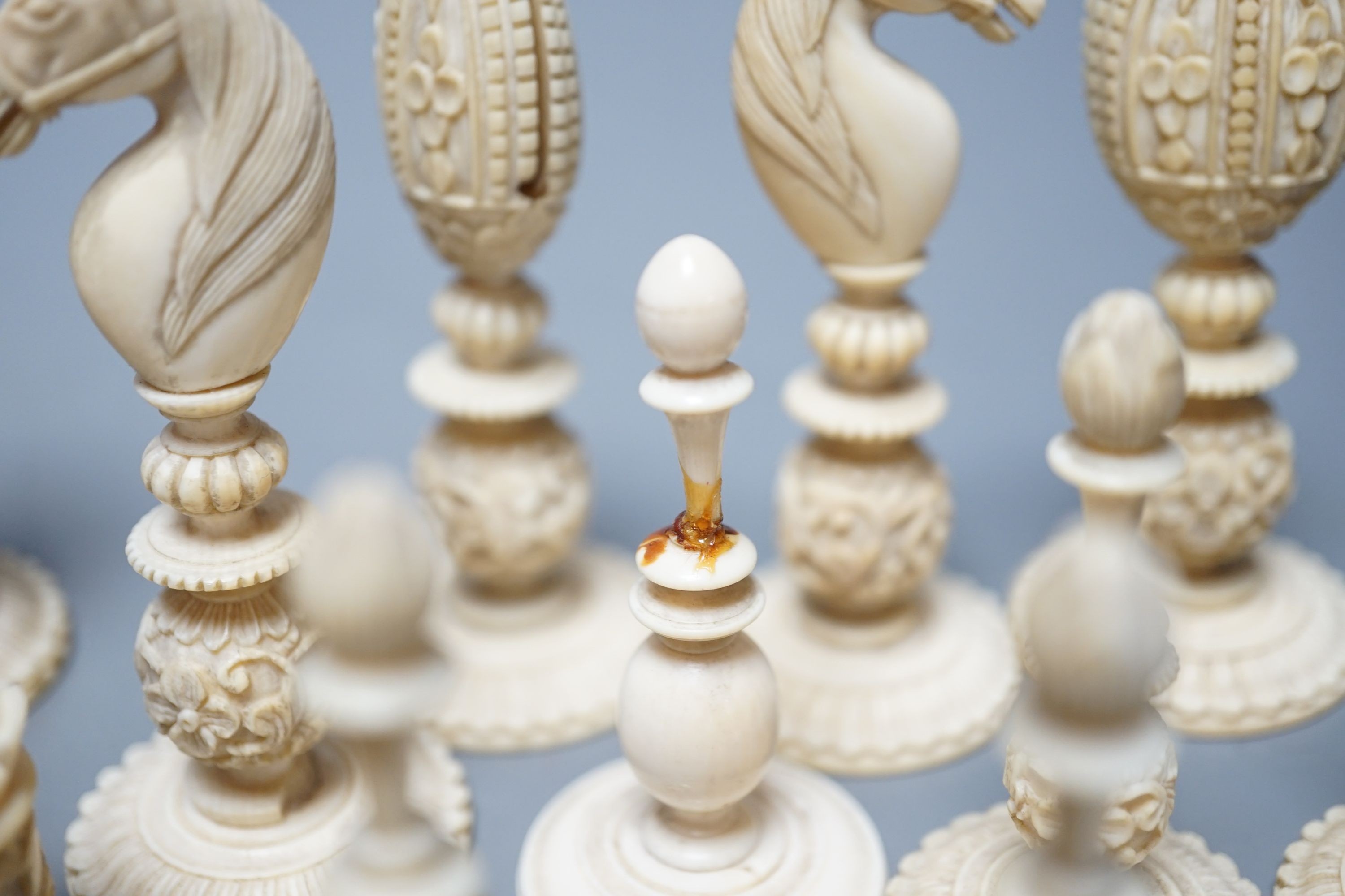 A 19th century Chinese export Burmese pattern carved and stained ivory chess set, one white pawn associated